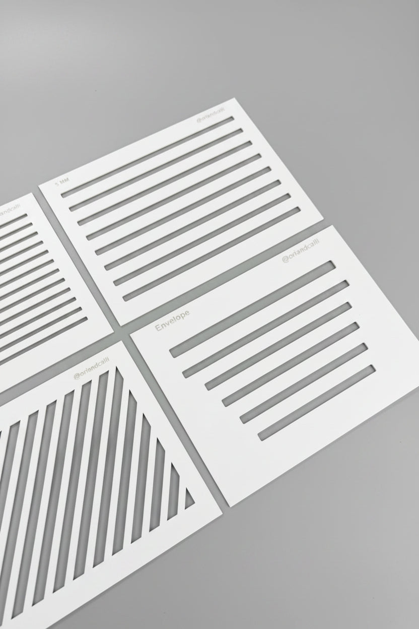 White stencil sheets with black linear patterns laid out on a black textured surface.
