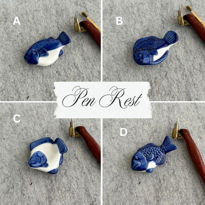 Blue and white fish-shaped pen rest on a gray surface with a white label in the center.