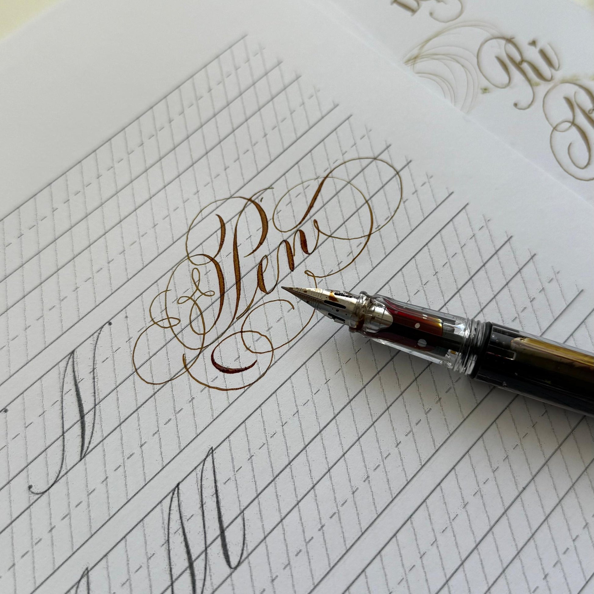 Calligraphy practice sheet with a pen on a white background